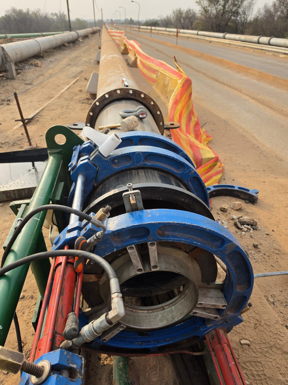 Butt-fusion welding machine aligned on an HDPE pipeline during a bridge crossing installation